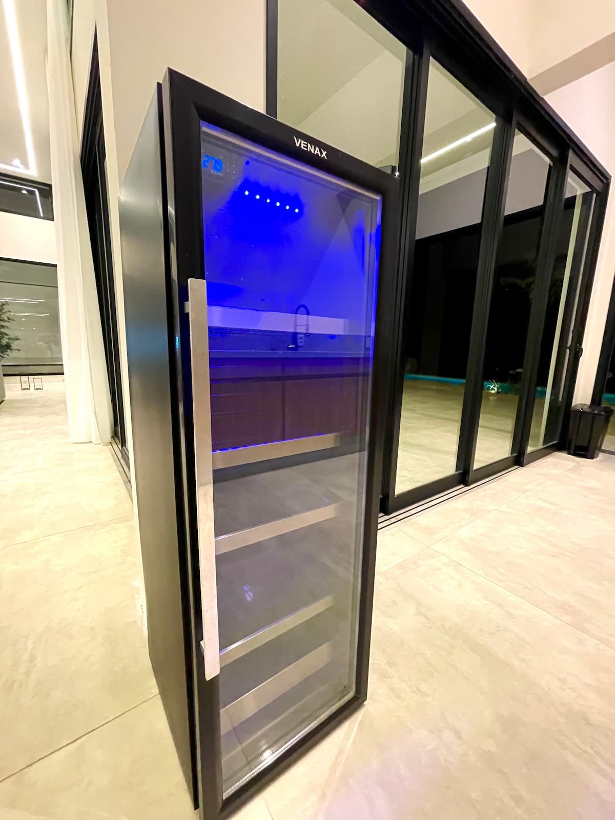 Sauna de vidro iluminada integrada aos ambientes da casa
