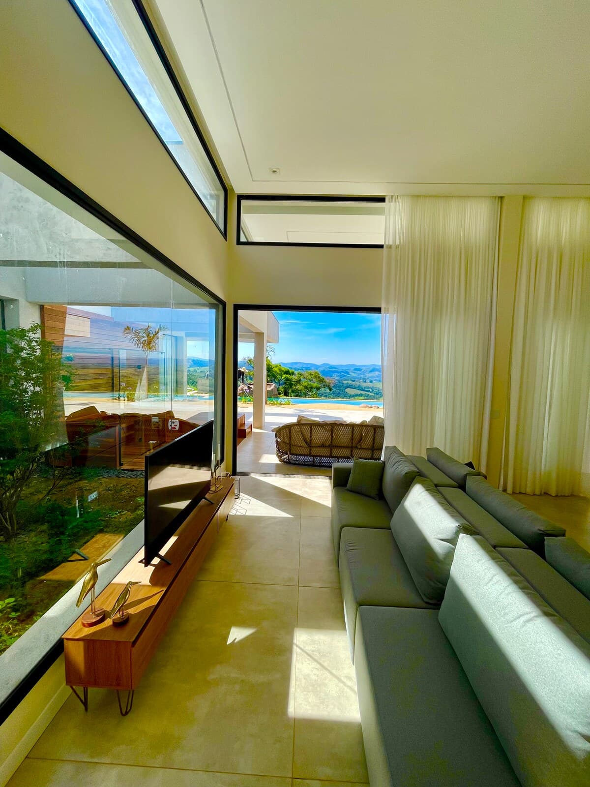 Sala de estar integrada à varanda com vista para a piscina