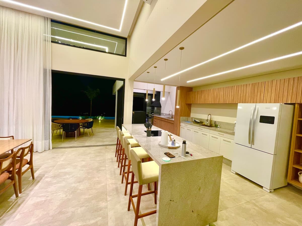 Cozinha ampla com ilha central e integração aos ambientes sociais