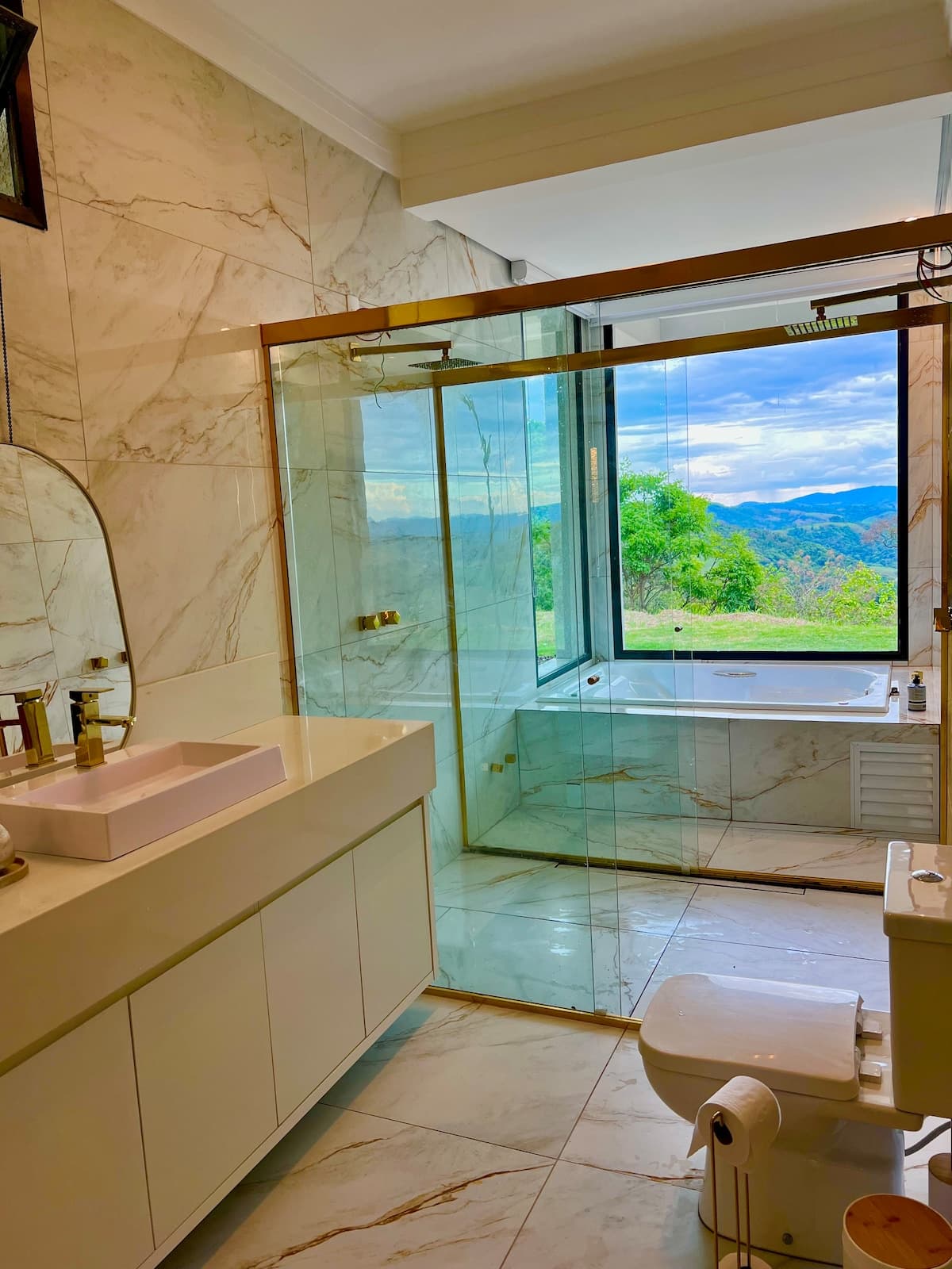 Ambiente de banho com vidro e vista para a natureza